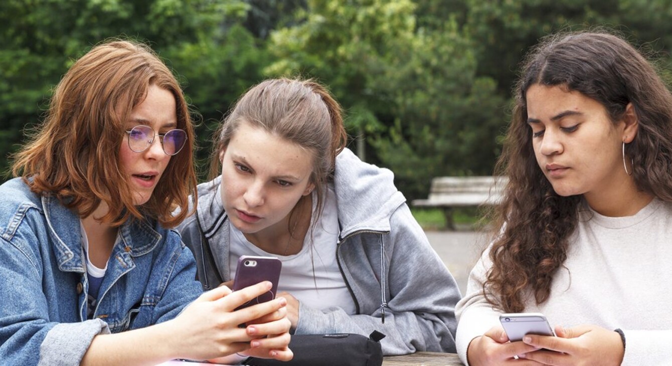 3 lycéennes regardant leur smartphone