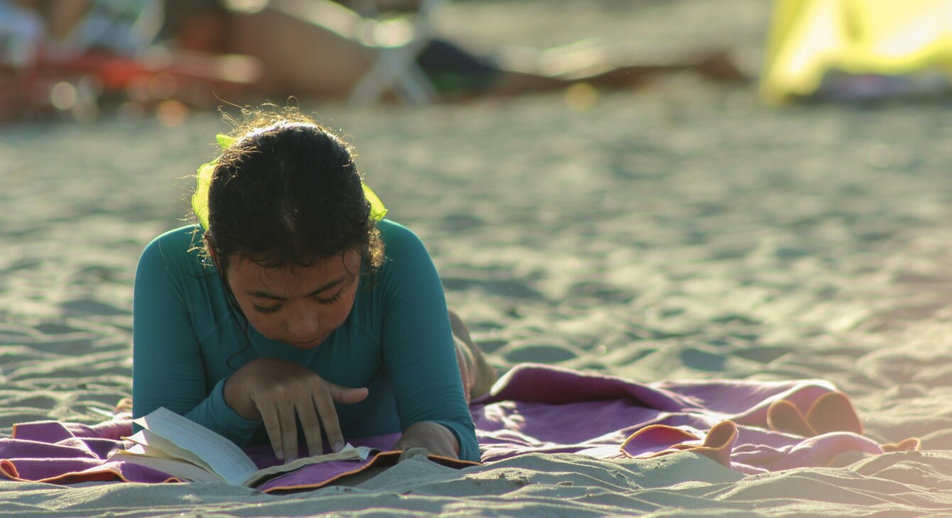 fille qui lis sur la plage