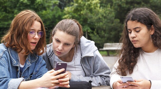 3 lycéennes regardant leur smartphone