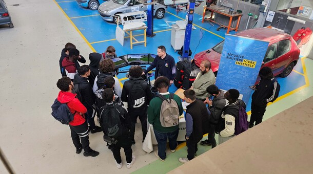 eleves vus du dessus à un stand de securite routiere