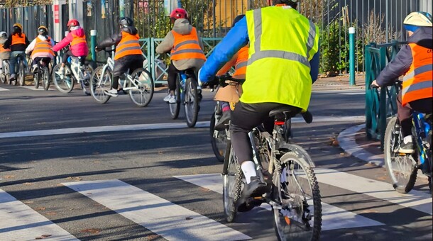 élèves de dos roulant à vélo sur la route par beau temps