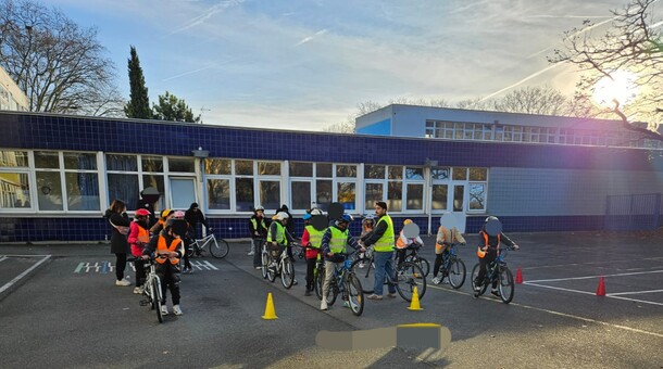 élèves sur leurs vélo devant leurs établissement par beau temps 