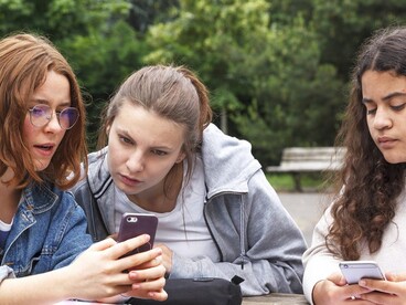 3 lycéennes regardant leur smartphone